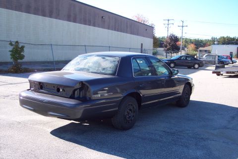 2001 Ford Crown Victoria - 2001 Ford Crown Victoria seen from the rear, missing its bumper and taillights.