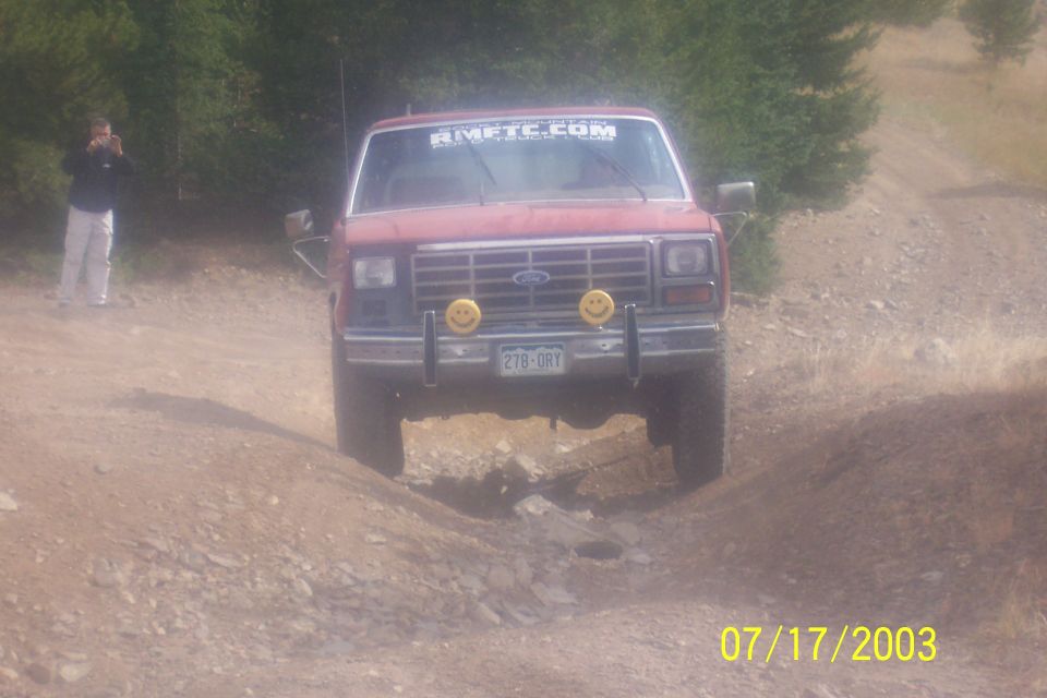 Red Bronco with smiley face lights and RMFTC.COM sticker on windshield