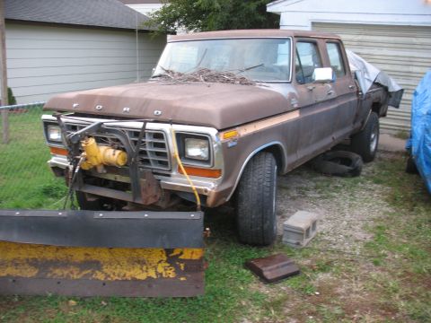 1978 Ford F-250 - This 1978 Ford F-250 truck is equipped with a plow and winch, parked outdoors.
