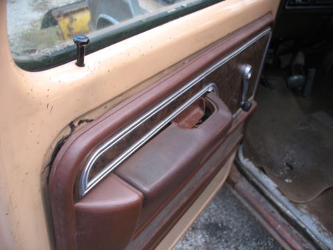 1978 Ford F-250 - Interior door panel detail showing wear and tear on the trim and handle area.