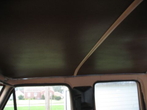 1978 Ford F-250 - View of the interior ceiling and window frame of a vehicle, with a glimpse of the outside.