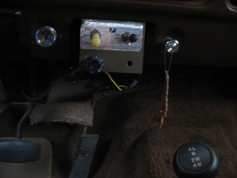 1978 Ford F-250 - The interior of a vehicle shows a custom-mounted control panel with switches and a knob, next to the ignition and a 4x4 gear selector.
