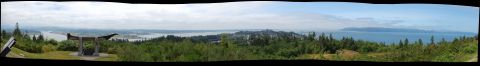 1985 Ford Ranger - A wide panoramic view captures a scenic overlook with a covered structure, overlooking a bay and forested hills under a partly cloudy sky.