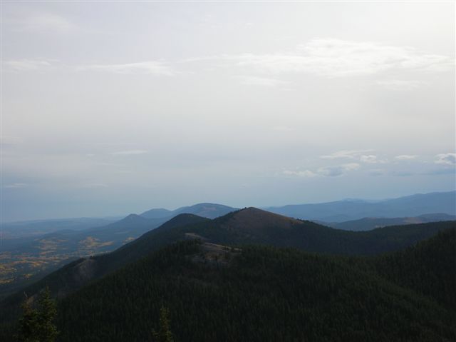 View of layered mountains and forested hills under a cloudy sky