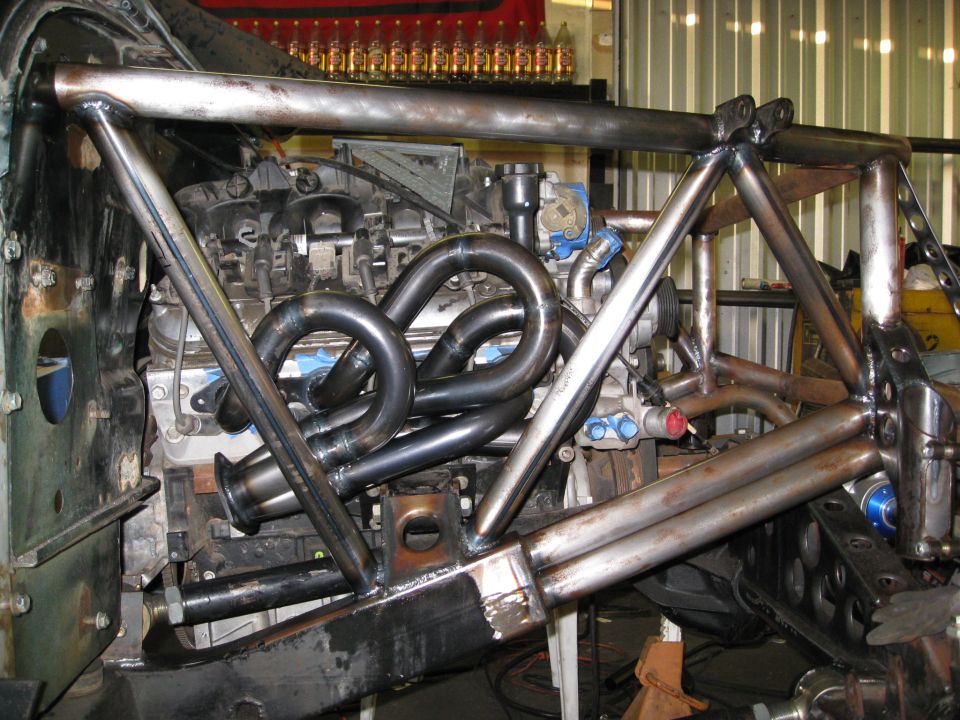 custom roll cage over engine with headers