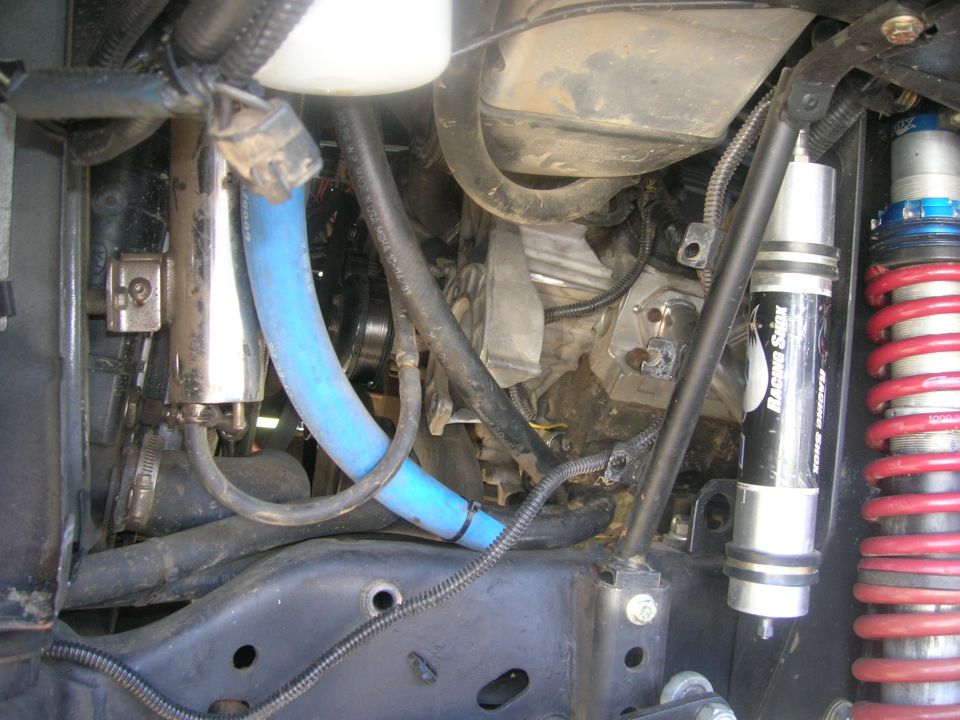 1996 Ford Bronco engine bay with blue hose, silver filter, and racing shock.