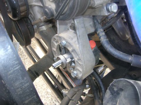 1996 Ford Bronco - Close-up view of the engine bay of a 1996 Ford Bronco, focusing on the power steering pump bracket and pulley system. Various hoses, belts,…