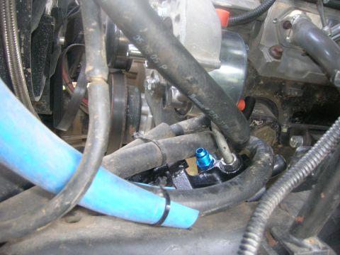 1996 Ford Bronco - A close-up view of engine components in a 1996 Ford Bronco, focusing on hoses and a power steering pump with a blue fitting.