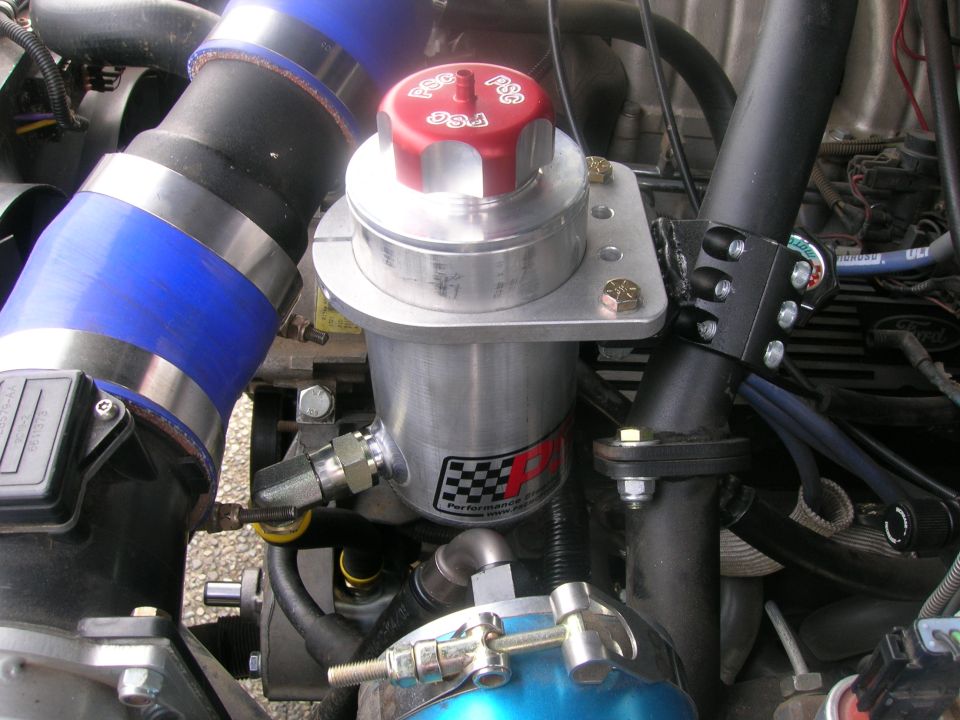 Modified engine bay with polished aluminum reservoir and blue silicone intake tube.