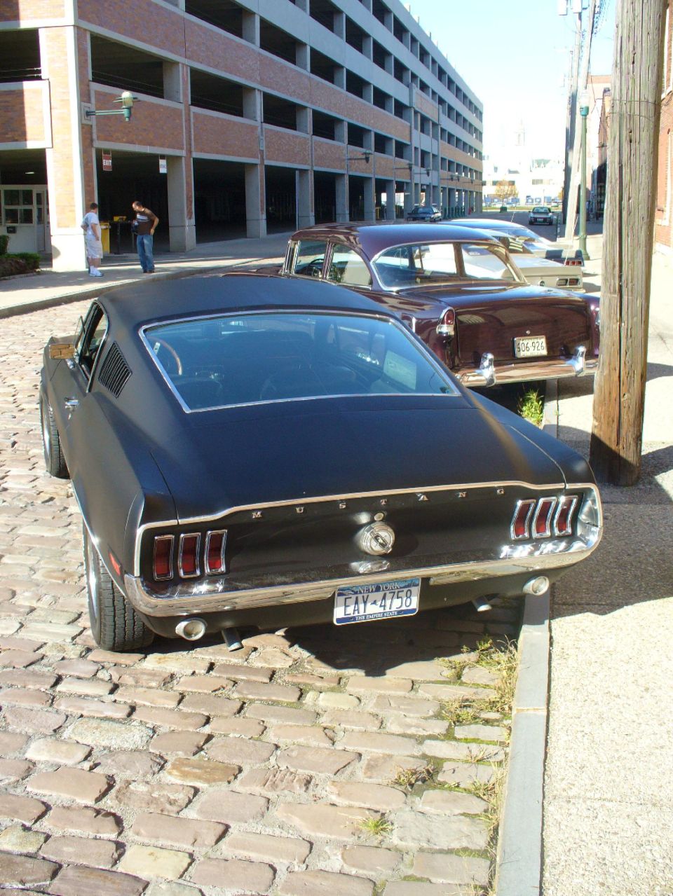 Black 1968 Ford Mustang Fastback rear view on cobblestone street