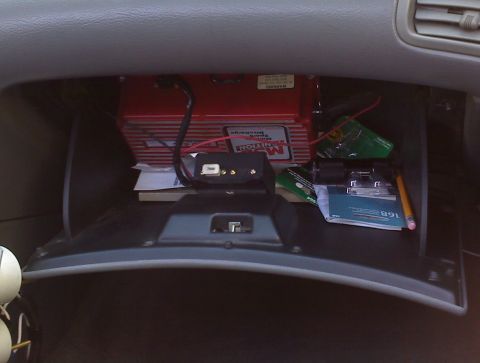 1993 Ford Probe - The interior of a vehicle's glove compartment is shown, containing various electronic parts and papers.