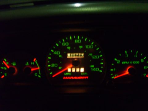 1993 Ford Crown Victoria - Night shot of a lit instrument cluster with green markings and red needles, showing a 140 mph speedometer with mechanical odometer reading…