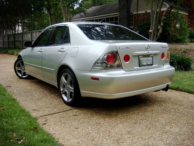 Silver Lexus IS 300 sedan from rear three-quarter angle on a driveway