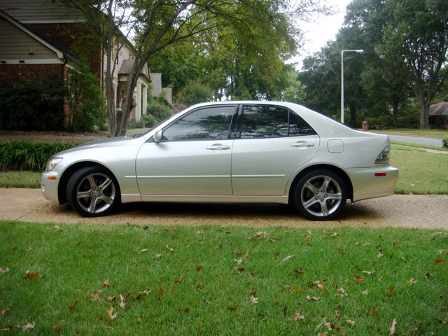 Silver Lexus IS sedan in side profile on a driveway