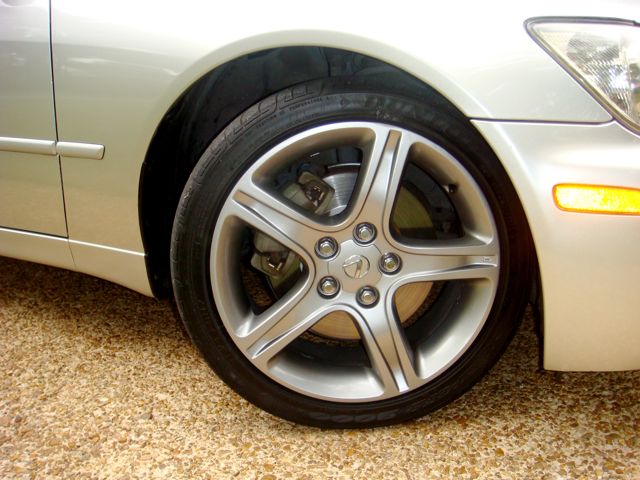 Five-spoke silver alloy wheel and brake rotor on silver sedan front corner