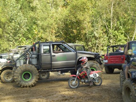 1997 Jeep Wrangler - A child in camouflage riding gear and a helmet sits on a small dirt bike with the number 10 on the side. The dirt bike is positioned in fro…