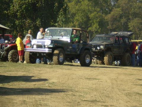 1997 Jeep Wrangler - A 1997 Jeep Wrangler is parked on a dirt lot with other vehicles and people.