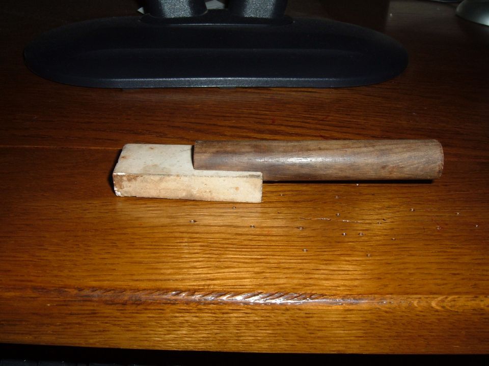 Wooden handle attached to a metal component on a wooden surface