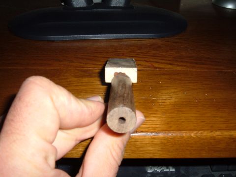 1998 BMW R1100GS ABS - A close-up view of a wooden component with a central hole, held by a person's hand.