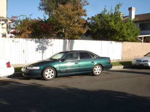 1993 Ford Taurus - This green 1993 Ford Taurus sedan is parked on a residential street.