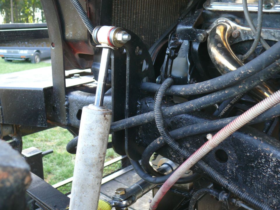 close-up of engine bay with shock absorber, hoses, and exhaust manifold