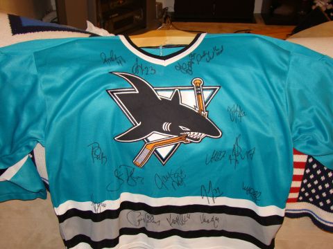 1989 Ford Bronco - A teal San Jose Sharks hockey jersey is displayed, covered in signatures from players.