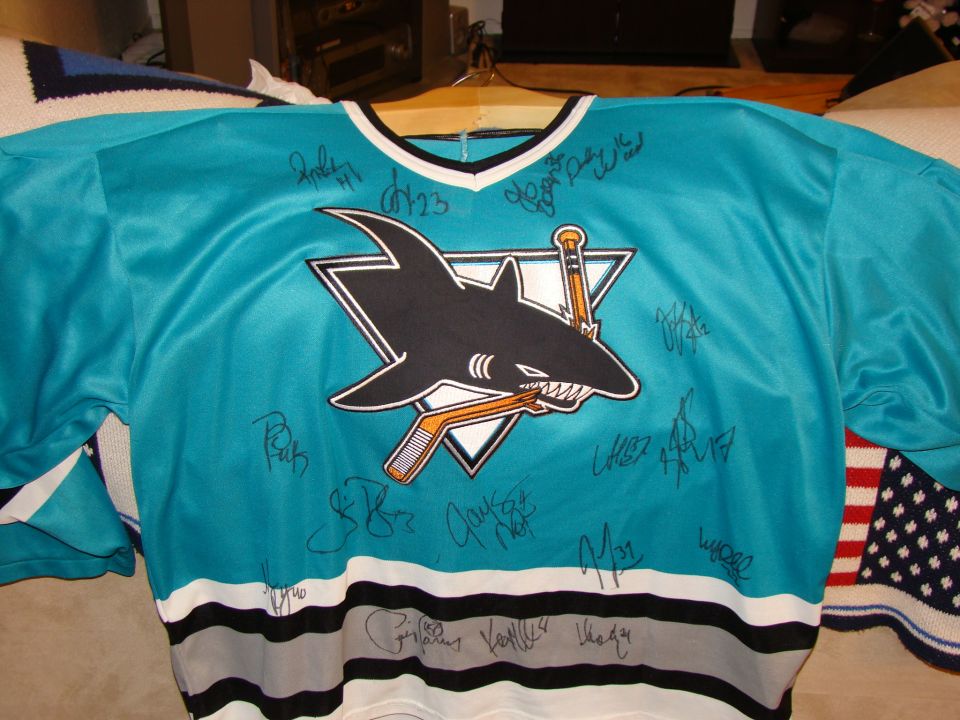 Teal San Jose Sharks hockey jersey with shark logo and autographs