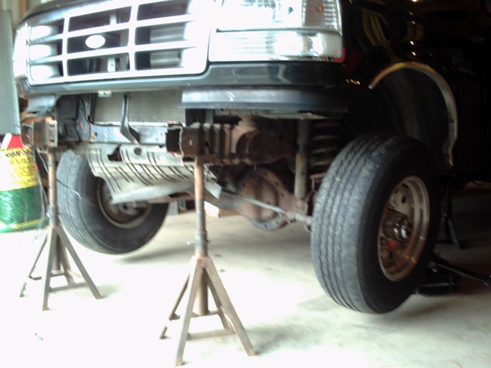 1996 Ford Bronco front end on jack stands, showing grille and suspension components