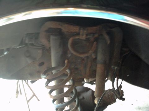 1996 Ford Bronco - Close-up view of corroded suspension components, including shock absorbers and coil springs.