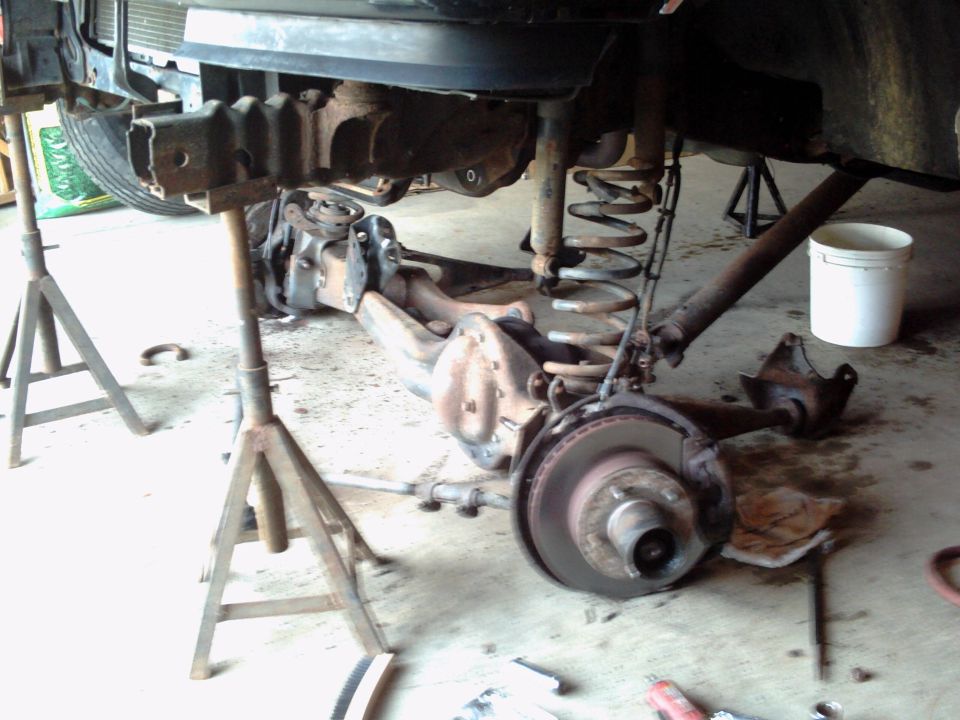 Rear axle and suspension components of a vehicle supported by jack stands