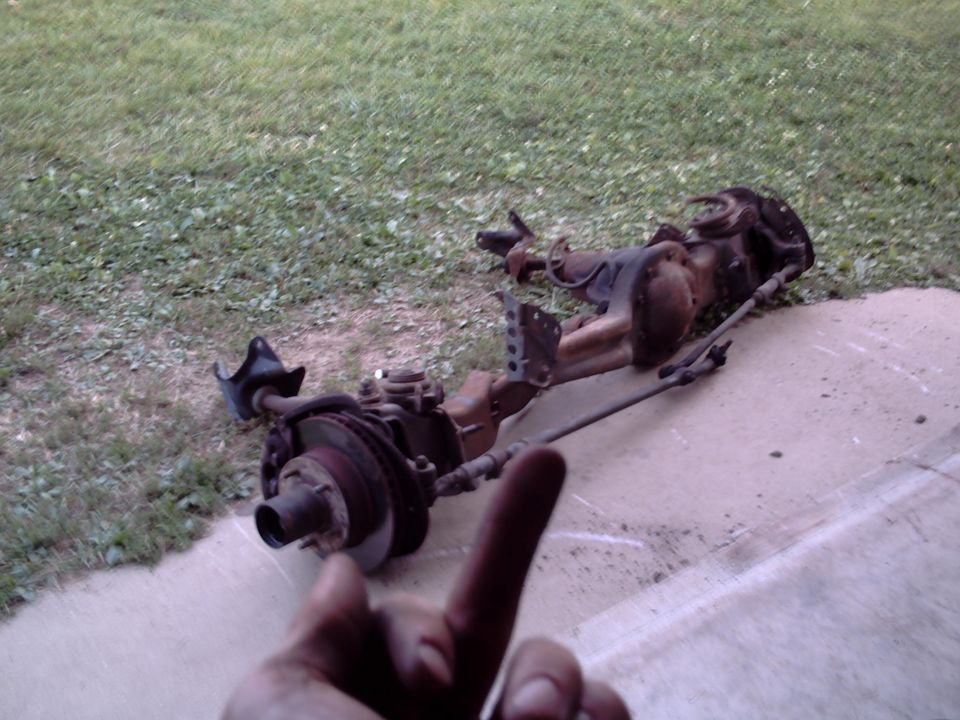 Front axle assembly with disc brakes and suspension components lying on the ground