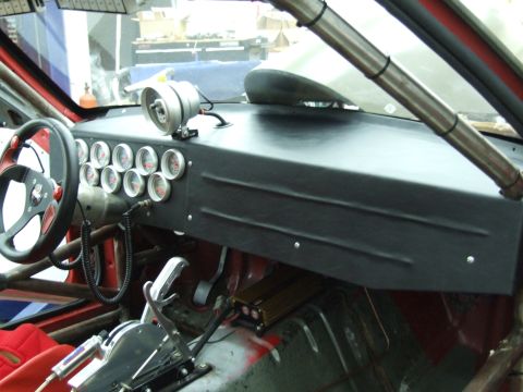 1990 Ford Mustang - The interior of a modified vehicle features a dashboard with numerous gauges and a racing steering wheel.