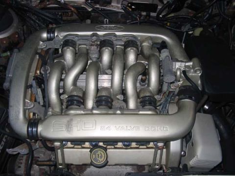 1990 Ford Taurus - Close-up of an engine intake manifold, clearly marked with 'SHO 32 VALVE DOHC'.