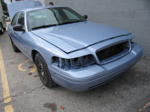 2001 Ford Crown Victoria - This 2001 Ford Crown Victoria is missing its headlights and has its hood and trunk open.