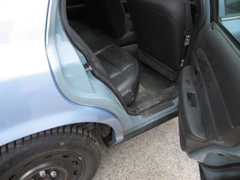 2001 Ford Crown Victoria - View of the rear passenger area and open door of a light blue sedan.
