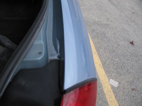 2001 Ford Crown Victoria - A partial view of a car's rear, focusing on the trunk area and a taillight assembly.
