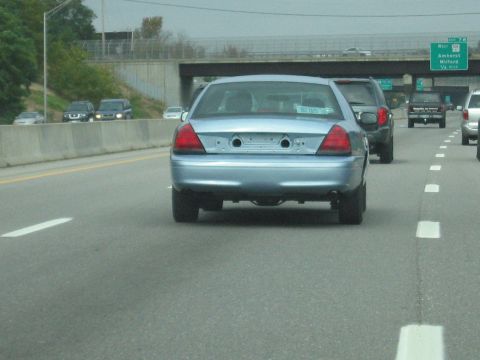 2001 Ford Crown Victoria - Light blue 2001 Ford Crown Victoria driving on a highway with other vehicles.