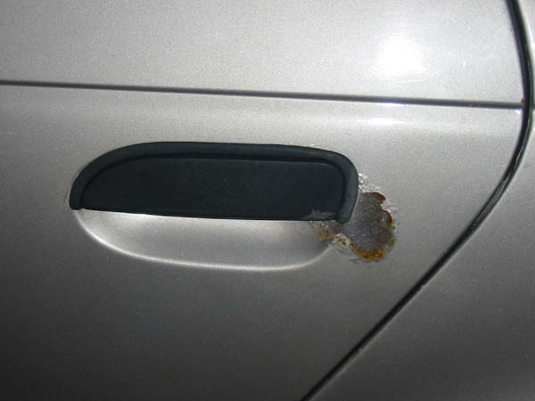 car door handle showing rust damage