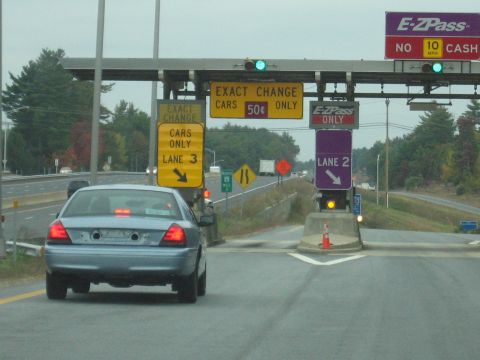 2001 Ford Crown Victoria - A blue 2001 Ford Crown Victoria approaches a toll booth on a highway.