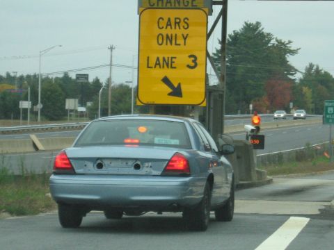 2001 Ford Crown Victoria - 2001 Ford Crown Victoria approaches toll booth, with other vehicles on the highway.