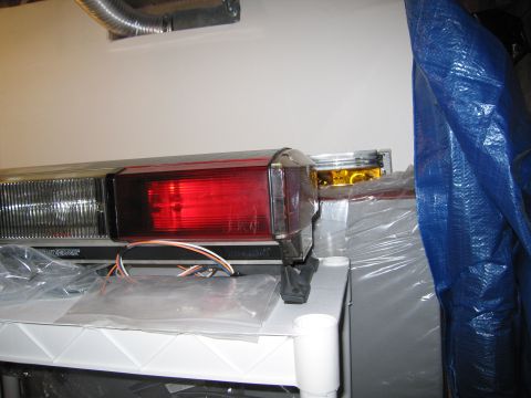 2001 Ford Crown Victoria - Close-up of an emergency light bar, red and clear lenses and exposed wiring.