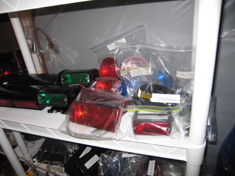 2001 Ford Crown Victoria - Collection of vehicle lights and parts stored on shelving units.