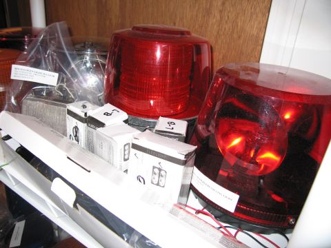 2001 Ford Crown Victoria - Boxes and domes for emergency lights are stored on a shelf, some labeled 'LED LIGHT'.