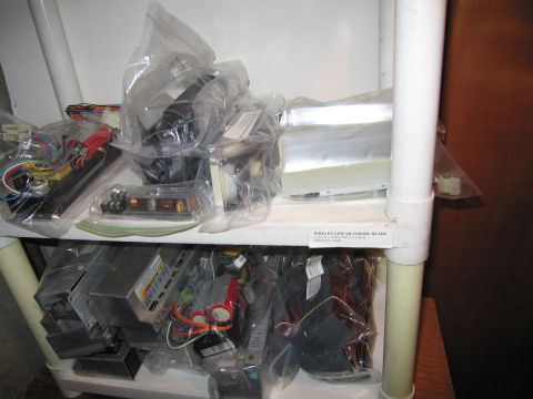 2001 Ford Crown Victoria - A storage shelf holds numerous electronic parts, including circuit boards and power supplies, all packaged in plastic.