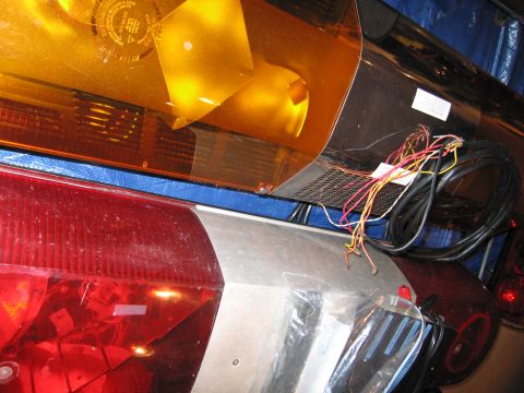 2001 Ford Crown Victoria - Close-up of an emergency light bar and tail lights, showing wiring and lenses.