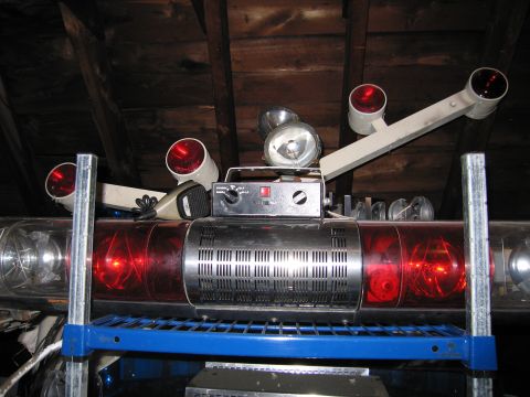 2001 Ford Crown Victoria - Emergency light bar assembly with multiple lights and a microphone, stored indoors.