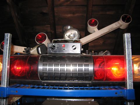 2001 Ford Crown Victoria - A collection of emergency lights and a control unit are stored on a blue shelf.
