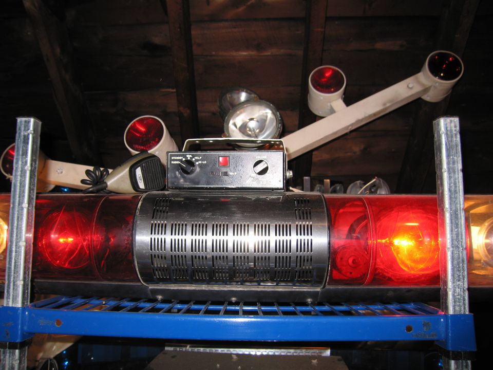 Emergency light bar with red lights and a control box with knobs and a red button