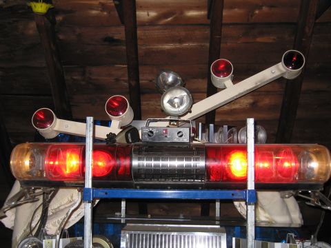 2001 Ford Crown Victoria - Emergency light bar assembly with multiple lights and spotlights is stored in an attic space.