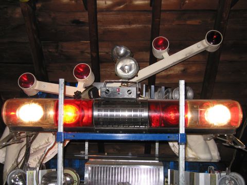 2001 Ford Crown Victoria - An emergency light bar with multiple red and white lights, along with spotlights, is mounted on a shelf.